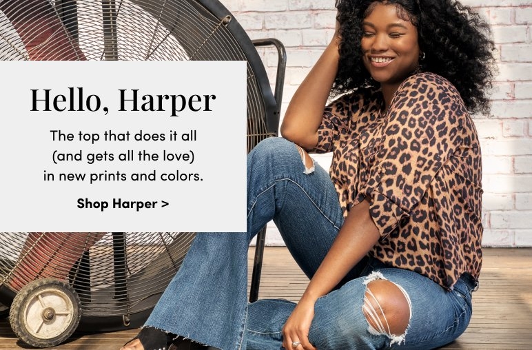 A woman wearing a leopard print top and ripped jeans sits smiling in front of a large fan. Text on the left reads: 'Hello, Harper. The top that does it all (and gets all the love) in new prints and colors.' Shop Harper 