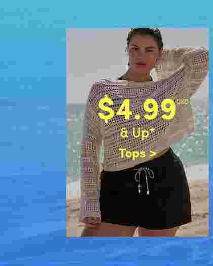 Woman standing on a beach wearing a white open-knit sweater and black drawstring shorts. Overlaid text reads 4.99 USD and up, Tops. Ocean background with bright blue water.