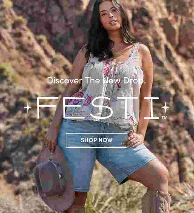 Woman standing confidently in front of rocky cliffs wearing a floral embroidered tank top, denim shorts, and holding a cowboy hat. Text reads Discover the New Drop FESTI with a Shop Now button.