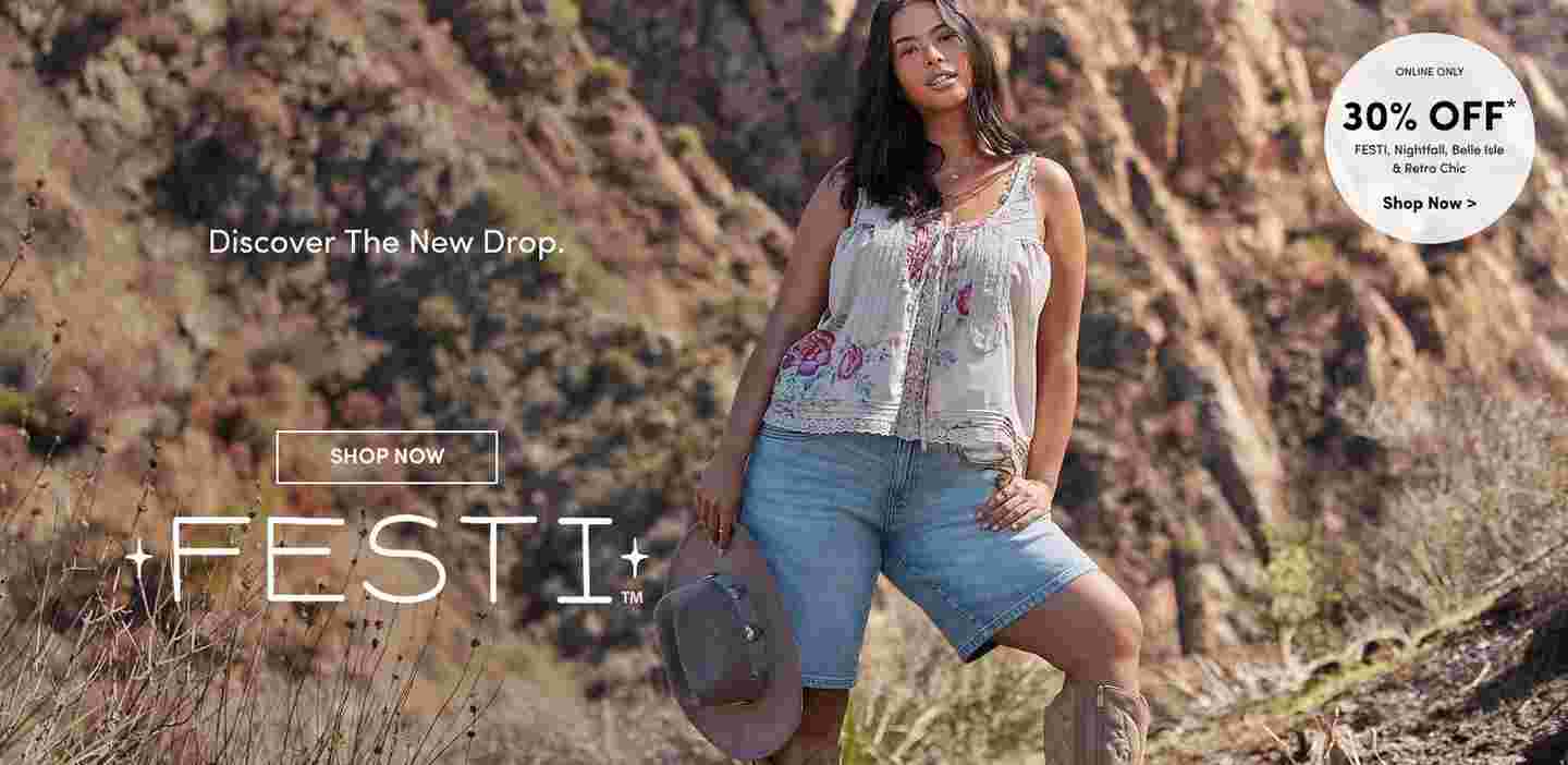 Woman standing confidently in front of rocky cliffs wearing a floral embroidered tank top, denim shorts, and holding a cowboy hat. Text reads Discover the New Drop FESTI with a Shop Now button.