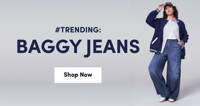 woman wearing baggy blue jeans, a white top, a navy varsity jacket, and a baseball cap poses confidently. Large text on the left reads: ‘#TRENDING: BAGGY JEANS’ with a white button below that says ‘Shop Now’ on a light gray background.