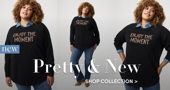 Two models stand outdoors in a lush green garden, one wearing a denim blouse with a bow tie neck and the other in a floral dress. Text on the right reads “New Drop. Step into the season. Belle Isle by Torrid. Unforgettable new styles for a new era. Explore the collection.”