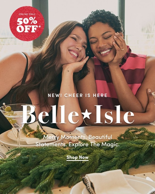'Two smiling women sit close together at a holiday table decorated with green pine garland and white plates. One woman wears a black strappy dress, and the other wears a sleeveless red and pink striped top. Both hold martini glasses with olives. Large white text across the center reads NEW! CHEER IS HERE Belle★Isle Merry Moments, Beautiful Statements. Explore The Magic. Below it is a white button that reads Shop Now. In the upper left corner, a red textured circle with white text reads ONLINE ONLY 50% OFF*.'