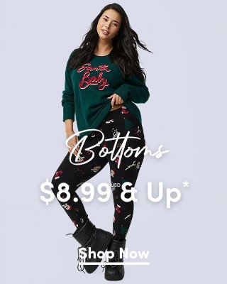 'A woman with long dark hair wears a dark green sweater with red script text reading Santa Baby and black leggings printed with holiday icons including candy canes, stockings, trees, and ornaments, paired with black lace-up boots against a light gray background. White script text across the center reads Bottoms. Large white text across the lower center reads $8.99 USD & Up*. A white underlined Shop Now button appears below.'*