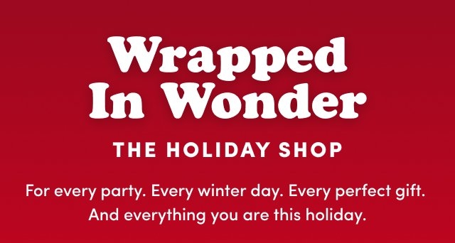 'Red background with large white text reading Wrapped In Wonder, uppercase white text below reading THE HOLIDAY SHOP, and smaller white paragraph text reading For every party. Every winter day. Every perfect gift. And everything you are this holiday.'