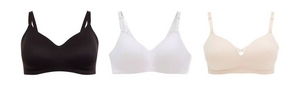 Three wire-free bras displayed flat on a white background. From left to right: a black wire-free bra with smooth cups, wide straps, and a wide supportive band, a white wire-free bra with smooth cups and wide straps, and a nude beige wire-free bra with smooth cups, a small crisscross detail at center gore, and wide straps.