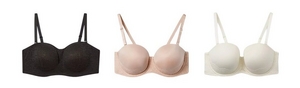 Three bras displayed flat on a white background. From left to right: a black lace-covered strapless bra with molded cups and attached wide straps, a blush pink strapless bra with smooth molded cups, lace band detail, and attached straps, and a cream-colored strapless bra with smooth molded cups, lace scalloped band detail, and attached straps.