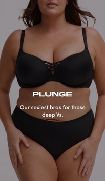 Model shown from chin to mid-thigh against a light gray background, wearing a black plunge bra with molded cups, adjustable straps, and a crisscross lattice detail at the center gore, paired with black mid-rise briefs. Model has long straight brown hair falling over shoulders. White text overlay reads 'PLUNGE' with subtext below reading 'Our sexiest bras for those deep Vs.'