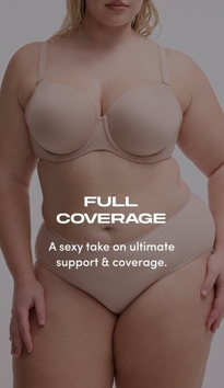 Model shown from chin to upper thigh against a light gray background, wearing a nude beige strapless bra with molded cups, side boning, and a sweetheart neckline, paired with matching nude beige high-waisted shaping briefs with a smooth waistband. Model has blonde wavy hair visible at shoulders. White text overlay reads 'FULL COVERAGE' with subtext below reading 'A sexy take on ultimate support & coverage.'.