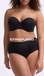 Model shown from shoulders to mid-thigh against a light gray background, wearing a black strapless bra with molded cups, lace side panel detailing, and a small bow at center gore, paired with black briefs featuring sheer mesh side panels. Model has curly brown hair. White text overlay reads 'STRAPLESS' across the midsection.