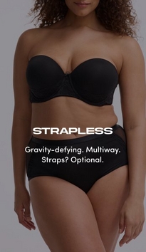 Model shown from shoulders to mid-thigh against a light gray background, wearing a black strapless bra with molded cups, lace side panel detailing, and a small bow at center gore, paired with black briefs featuring sheer mesh side panels. Model has curly brown hair. White text overlay reads 'STRAPLESS' with subtext below reading 'Gravity-defying. Multiway. Straps? Optional.'