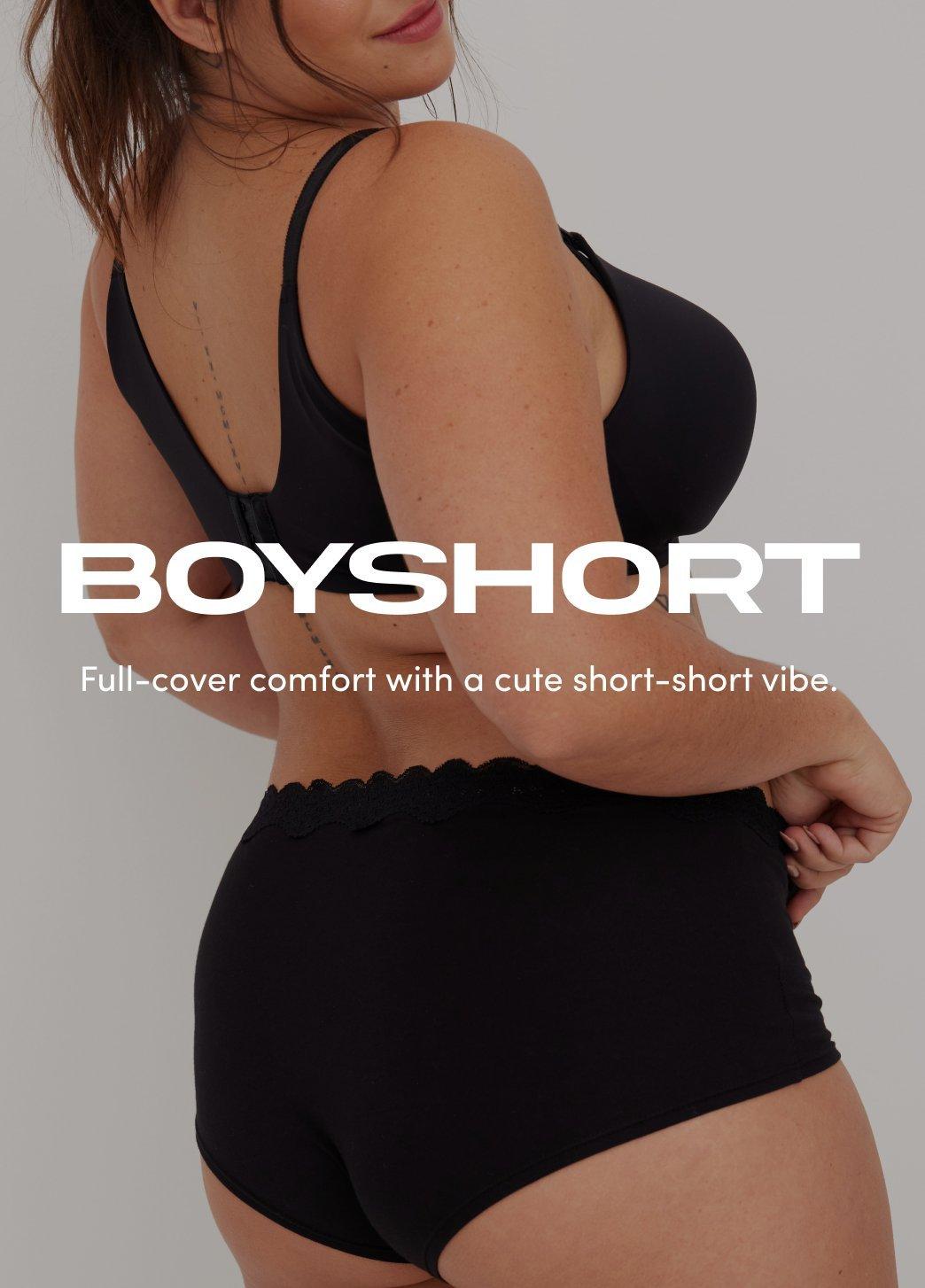 Model wearing a black bra and matching boyshort underwear, shown from a back and side angle against a neutral background. On image text reads Boyshort. Full-cover comfort with a cute short-short vibe.