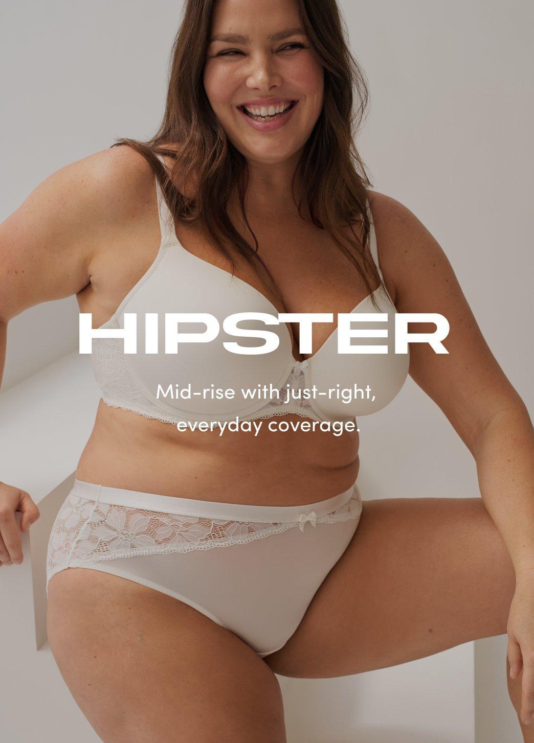 Model wearing a white bra and matching hipster underwear, seated and smiling against a neutral background. On image text reads Hipster. Mid-rise with just-right, everyday coverage.