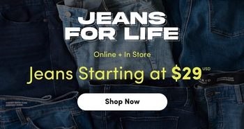'A promotional banner with a dark denim blue background featuring a close-up of folded and stacked jeans in various washes. At the top in large bold white text reads Jeans For Life. Below in small white text reads Online + In Store, followed by the text Jeans Starting at $29 USD in bold yellow-green text. At the bottom is a white rounded button with dark text reading Shop Now.'
