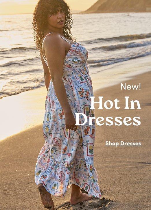 Torrid New Dresses advertisement: Model in a tropical postcard print maxi dress on a beach. Text: New! Hot In Dresses. Shop Dresses.