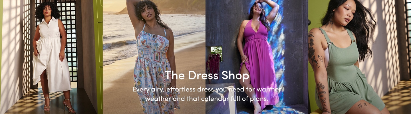 A promotional banner for 'The Dress Shop' with the tagline 'Every airy, effortless dress you need for warmer weather and that calendar full of plans.' in white text overlaid across four side-by-side photos. In the first photo, a woman with short curly dark hair stands in a sunlit tiled interior with a geometric lattice window casting shadows, wearing a white sleeveless button-front shirt dress with an asymmetric hem and gold strappy heeled sandals. In the second photo, a woman with curly dark hair stands on a sandy beach with ocean waves behind her, one arm raised overhead, wearing a white halter midi dress with a colorful vintage-style travel postcard print and a smocked waist. In the third photo, a woman with long dark wavy hair and hoop earrings leans against a textured gray concrete wall with blue painted light effects, smiling with one arm raised, wearing a bright magenta halter maxi dress with a V-neckline, ruched waist, and front slit. In the fourth photo, a woman with long dark hair and tattoos on both arms sits in a sunlit doorway, wearing a sage green sleeveless square-neck mini dress with button detail and a cutout side.