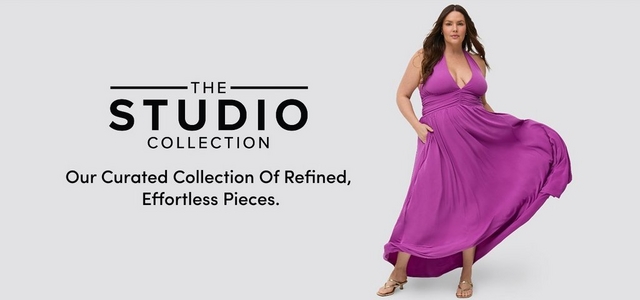 A promotional banner for 'The Studio Collection' with the tagline 'Our Curated Collection Of Refined, Effortless Pieces.' in black text on the left side of a light gray background. A woman with long dark brown wavy hair stands on the right, one hand in her pocket, wearing a bright magenta halter maxi dress with a deep V-neckline, ruched waist, and flowy skirt that billows to one side, paired with gold strappy heeled sandals.