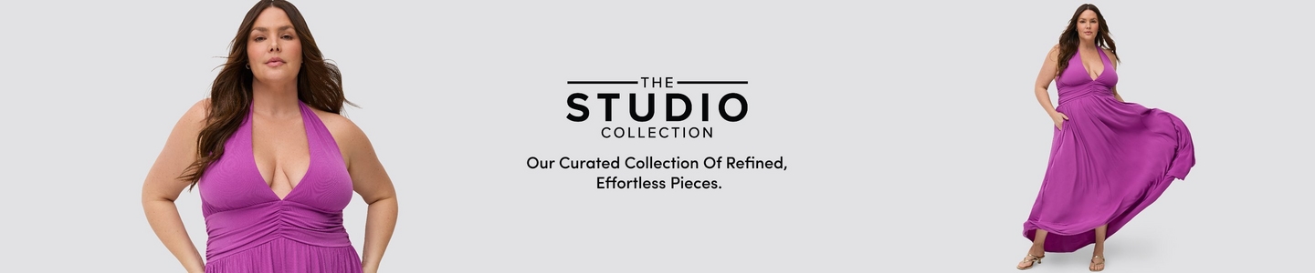 A promotional banner for 'The Studio Collection' with the tagline 'Our Curated Collection Of Refined, Effortless Pieces.' in black text on a light gray background. The same woman appears twice on either side of the text, cropped at different framings. She has long dark brown wavy hair and wears a bright magenta halter maxi dress with a deep V-neckline, ruched waist, and flowy skirt, paired with gold strappy heeled sandals. On the left she is shown from the waist up, and on the right she is shown full length with the skirt flowing to one side.