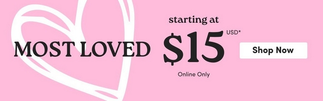 'Promotional banner for Torrid with a solid bright pink background. On the left side is a large white hand-drawn style heart outline that extends to the center of the banner. Overlaid on the left side in large bold dark text is 'MOST LOVED'. To the right of center, smaller dark text reads 'starting at' above very large bold dark text reading '$15' with small text to the upper right reading 'USD' with an asterisk. Below the price, small dark text reads 'Online Only'. To the right is a white rectangular button with bold dark text reading 'Shop Now'.'