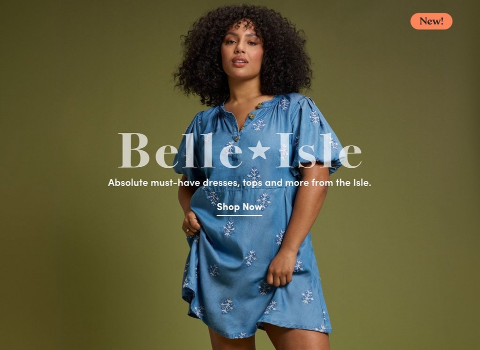 'Promotional banner for Torrid featuring the Belle Isle collection against a dark olive green background. A plus-size woman with medium skin tone and short voluminous dark curly hair stands looking slightly upward. She is wearing a medium blue chambray short-sleeve mini dress with a henley-style button neckline, puff sleeves, and an allover white snowflake embroidery pattern, with a ring visible on her hand. In the upper right corner, a coral-orange rounded badge reads 'New!' in dark text. Overlaid across the center in large semi-transparent white serif text with a star graphic is 'Belle Isle', with smaller white text below reading 'Absolute must-have dresses, tops and more from the Isle.' Below that, bold white underlined text reads 'Shop Now'.'