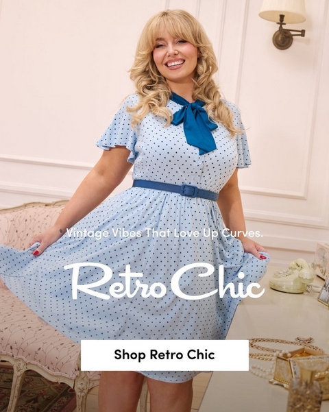 'Promotional banner for Torrid featuring Retro Chic, set in an elegant vintage-styled room with white paneled walls, a wall-mounted brass lamp, a pink floral upholstered settee, and a small vanity table with a cream rotary telephone and jewelry visible on the right side. A plus-size woman with light skin tone and long wavy blonde hair with bangs stands smiling broadly, holding out the skirt of her dress with both hands and showing red nail polish. She is wearing a light blue polka dot fit-and-flare midi dress with flutter sleeves, a teal satin bow at the collar, and a matching teal belt at the waist. Smaller white text reads 'Vintage Vibes That Love Up Curves.' above large white cursive script text reading 'Retro Chic'. At the bottom is a white rectangular button with bold dark text reading 'Shop Retro Chic'.'
