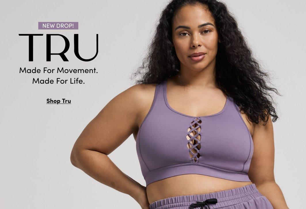 'Promotional banner for Torrid featuring new sandals. A pair of gold flat thong sandals with floral pearl and flower embellishments at the toe strap are displayed on sandy ground near large rocks, with a blurred coastal landscape and blue sky visible in the background. Small white text at the top reads 'Just In!' above larger bold white text reading 'Snag New Sandals'. Below that, small white underlined text reads 'Shop Now'.'