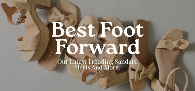 'Promotional banner for Torrid featuring a flat lay overhead photo of multiple neutral-toned raffia and woven textured women's sandals and heels arranged on a light gray surface. The shoes include styles with bow details, ankle straps with gold buckles, block heels, platform soles, and open toes, all in warm beige and tan tones. The Torrid brand name is visible on the insole of one shoe. Overlaid in large bold white serif text is 'Best Foot Forward' with smaller white text below reading 'Our Latest Trending Sandals, Heels And More.'.'