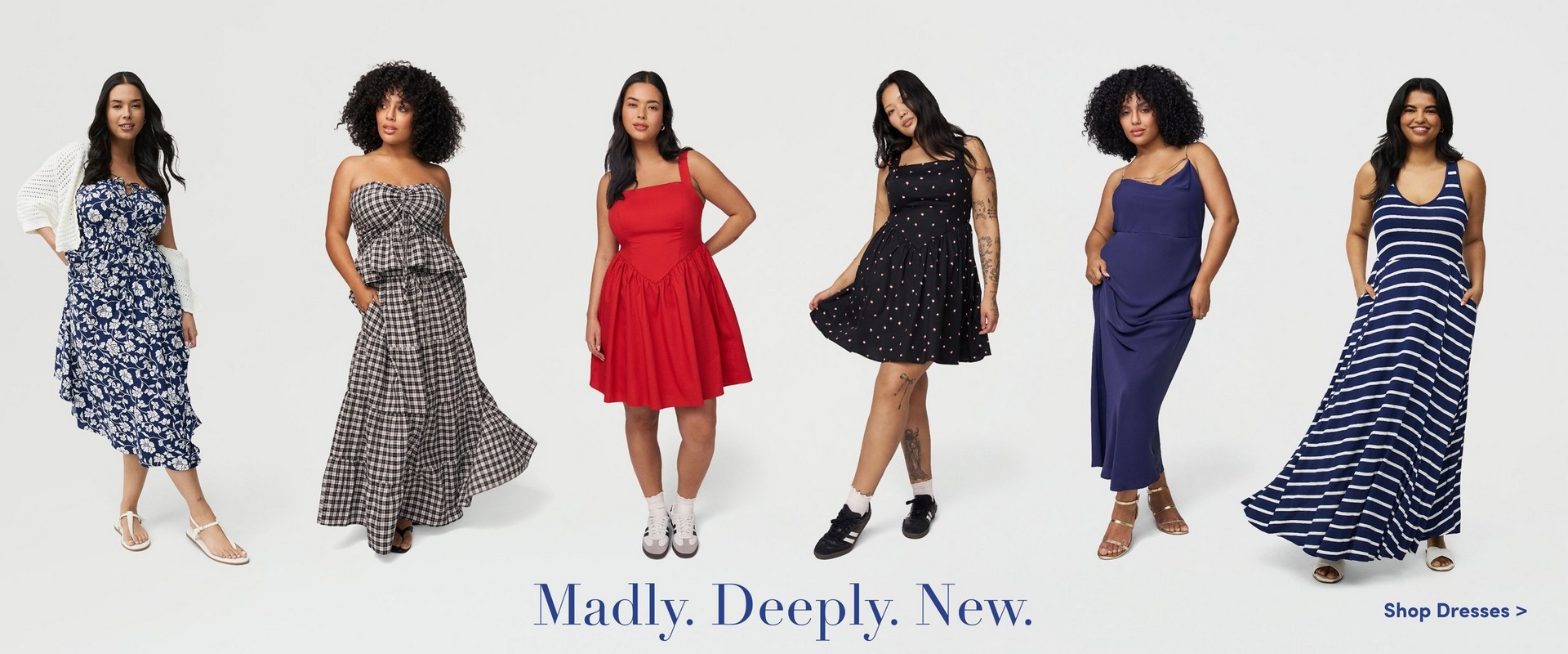 'A wide promotional banner featuring six women modeling dresses against a light gray background. From left to right: the first woman has long dark hair and wears a navy blue floral midi dress with a white open-knit cardigan and white strappy sandals. The second woman has voluminous curly black hair and wears a black and white gingham strapless tiered maxi dress with a bow detail at the bust, hands in pockets. The third woman has long dark hair and wears a red square-neck fit-and-flare mini dress with thick straps, paired with white ankle socks and chunky sneakers. The fourth woman has long dark hair and visible arm tattoos, and wears a black mini dress with small white polka dots and thin straps, paired with black sneakers and white ankle socks. The fifth woman has curly dark hair and wears a solid navy blue maxi dress with thin spaghetti straps and a draped silhouette, paired with tan strappy heeled sandals. The sixth woman has long dark hair and wears a navy and white horizontal stripe maxi dress with a racerback neckline, hands in pockets, paired with white open-toe sandals. Blue serif text at the bottom center reads 'Madly. Deeply. New.' with a blue link on the lower right reading 'Shop Dresses >'.'
