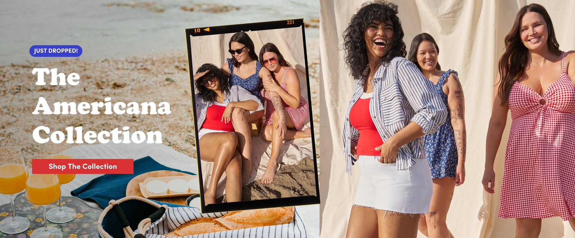 'A wide promotional banner for The Americana Collection. The left side shows a beach scene with two glasses of orange juice, a baguette on a cutting board, a striped tote bag, and a blue blanket on the sand near the water's edge. Overlaid on the left is a blue rounded badge reading 'JUST DROPPED!' in white text, and large white serif text reading 'The Americana Collection' with a red rounded rectangle button below reading 'Shop The Collection' in white text. In the center, a photo printed to look like a developed film negative shows three women sitting together on a sandy beach: one wearing a navy floral ruffle-strap dress, one in a red and white gingham dress with a knotted front, and one in sunglasses wearing a striped top. On the right, three women stand in front of a cream fabric backdrop on sand: the first has voluminous curly dark hair and wears a red tank top under an open blue and white striped button-down shirt with a white denim mini skirt; the second in the middle wears a navy blue floral ruffle-strap dress and has arm tattoos; the third has long wavy brown hair and wears a red and white gingham fit-and-flare mini dress with a knotted bust detail and thin straps.'