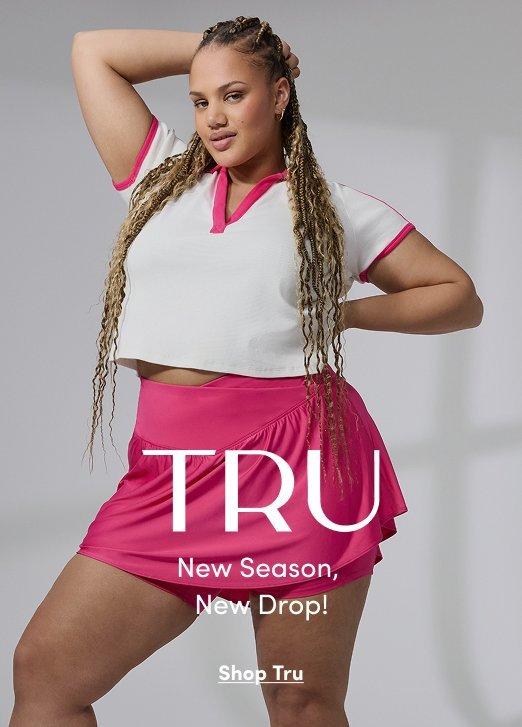 Woman wearing a white cropped polo and pink skort from Tru collection. Image text reads TRU, New Season, New Drop!, Shop Tru.