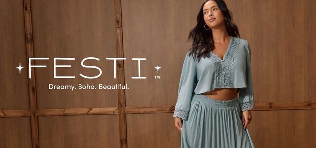 A wide promotional banner set against a warm brown wood-paneled wall background. On the right side, a woman with long dark wavy hair and gold hoop earrings looks off to one side, wearing a dusty teal two-piece set consisting of a cropped long-sleeve V-neck top with crochet lace trim and button front detail, paired with a flowing pleated maxi skirt with a smocked waistband. She wears a ring on her right hand. On the left side in large white text reads '+FESTI+' with small four-pointed stars flanking the name and a 'TM' superscript, and below it in smaller white text, 'Dreamy. Boho. Beautiful.'