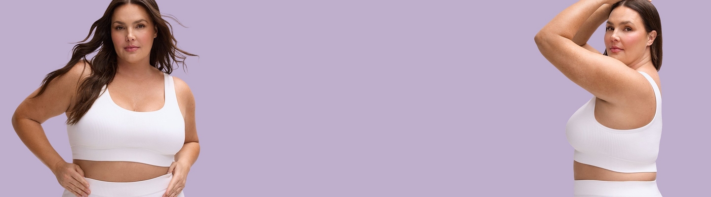 A wide promotional banner for the Seamless Rib Collection featuring a model against a light lavender background. On the left, she is shown from the waist up facing forward, wearing a white ribbed seamless scoop-neck bra and matching bottoms. On the right, she is shown in a side profile with her arms raised, showcasing the fit of the white ribbed seamless bra.