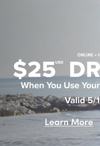 A cropped vertical version of the same coastal promotional banner, showing the rocky shoreline background with partially visible white text reading 'ONLINE + IN' at the upper right, '$25 USD** DR' and 'When You Use Your' and 'Valid 5/1' in large bold white text. An underlined 'Learn More' link appears near the bottom center.