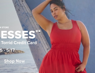 A vertical promotional banner showing a woman with dark curly hair wearing a red sleeveless dress with a smocked waistband and gathered skirt, leaning against a weathered wooden post with a blue wall and coastal scenery behind her. She wears gold hoop earrings and has one arm raised. Partially visible white text overlaid on the left reads 'N STORE', 'ESSES**', 'Torrid Credit Card', '5 - 5/17', and an underlined 'Shop Now' link near the bottom.