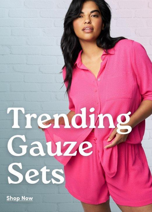 Woman wearing a bright pink gauze shirt and matching shorts with text reading “Trending Gauze Sets” and “Shop Now.”