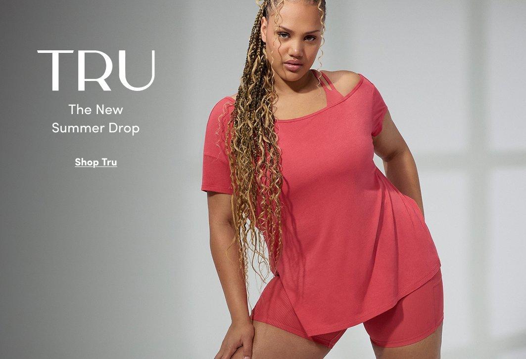 Promotional image featuring a model wearing a coral pink activewear set with an oversized short sleeve top and fitted biker shorts. Text reads “TRU The New Summer Drop” with “Shop Tru” below.