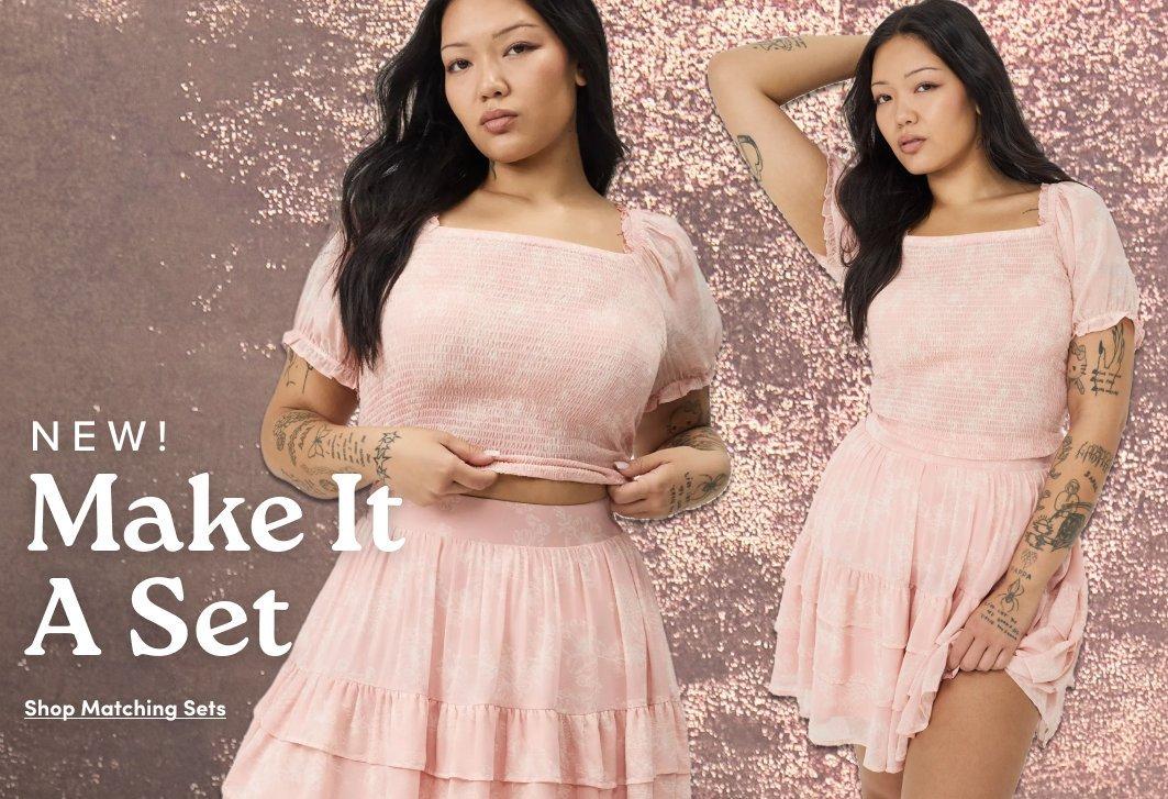 Promotional image featuring two side-by-side views of a model wearing a light pink matching set with a smocked puff sleeve crop top and tiered mini skirt against a glittery pink background. Text reads “NEW! Make It A Set” with “Shop Matching Sets” below.