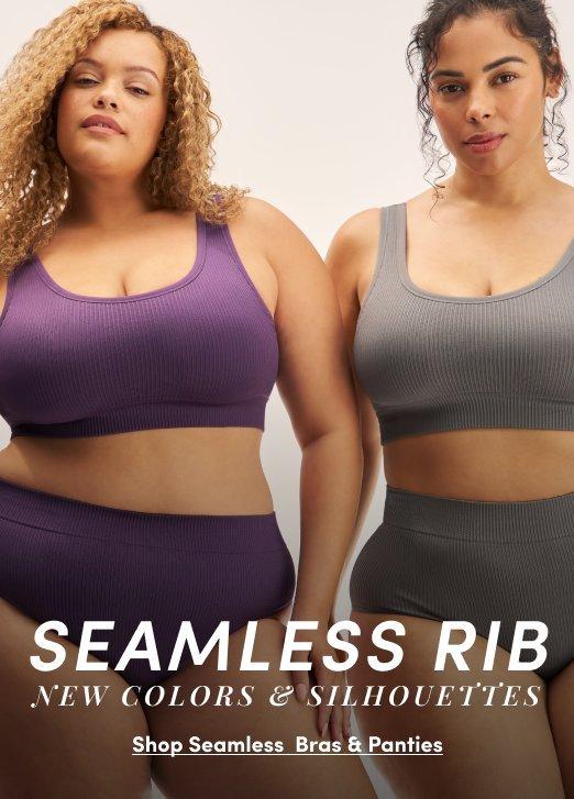 A promotional banner with a light gray background showing two women standing side by side. The woman on the left has voluminous curly blonde hair and wears a deep purple seamless ribbed sports bra with a scoop neckline and matching high-waist shorts. The woman on the right has long dark curly hair pulled back and wears a medium gray seamless ribbed sports bra with a scoop neckline and matching high-waist shorts. White text overlay at the bottom reads 'SEAMLESS RIB' in large bold letters with smaller text reading 'NEW COLORS & SILHOUETTES' and an underlined link reading 'Shop Seamless Bras & Panties.'