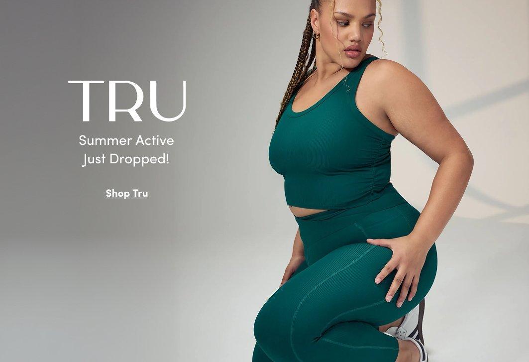 A promotional banner with a light gray background. A woman with short dark hair sits in a relaxed pose with one hand on her knee, wearing a teal ribbed sports bra and matching teal wide-leg skirt with a side slit, showing a peek of a coordinating bike short underneath. White text to the left reads 'TRU' in large letters with smaller text reading 'Summer Active Just Dropped!' and an underlined link reading 'Shop Tru.'