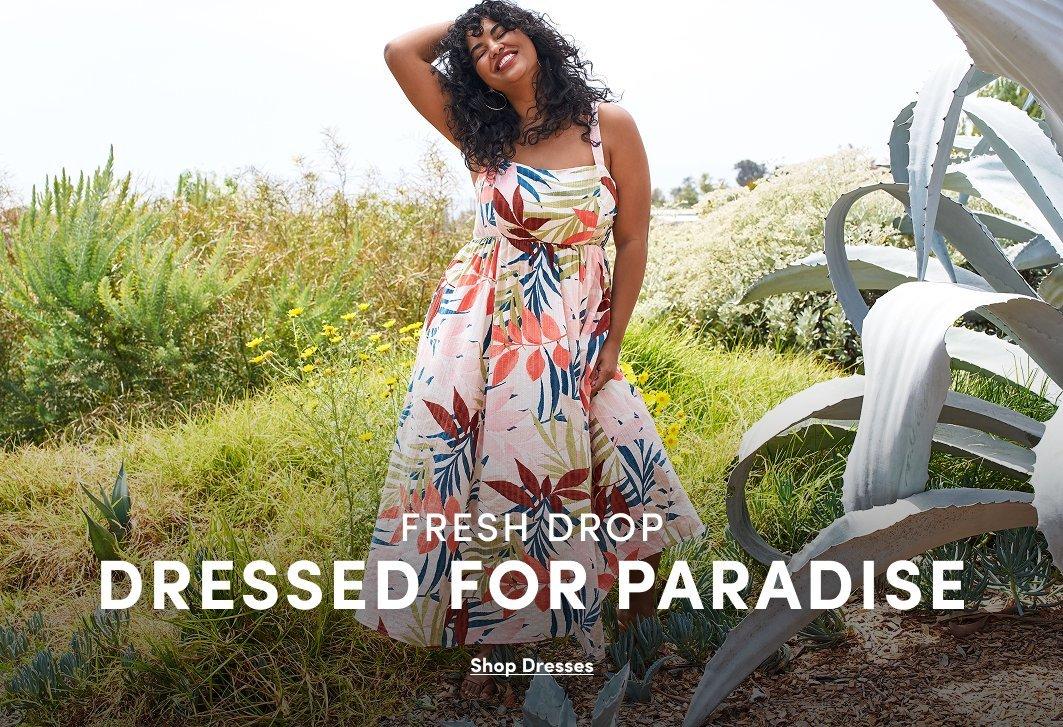 Claude responded: A promotional banner showing a woman with short curly dark hair standing outdoors among large agave plants and green foliage, one hand raised to her hair.A promotional banner showing a woman with short curly dark hair standing outdoors among large agave plants and green foliage, one hand raised to her hair. She wears a sleeveless midi dress with a square neckline and a cream background with a large-scale tropical leaf print in red, orange, blue, and green. White text overlay reads 'FRESH DROP' in small text and 'DRESSED FOR PARADISE' in large bold text, with a small underlined link reading 'Shop Dresses.'