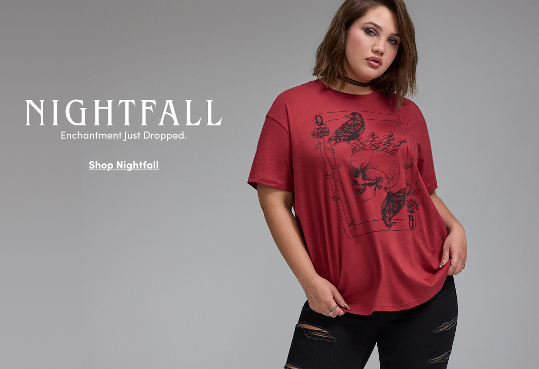 Model wearing an oversized red Nightfall graphic T-shirt with a skull, raven, and playing card design, paired with distressed black jeans and a black choker. Text reads, “Nightfall. Enchantment Just Dropped.” with “Shop Nightfall.”