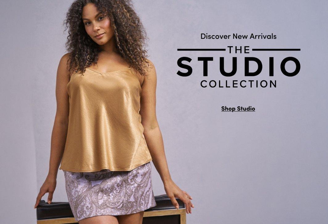 Model wearing a champagne satin camisole paired with a lilac paisley mini skirt, standing beside a bench. Text reads, “Discover New Arrivals. The Studio Collection,” with a “Shop Studio” call to action.