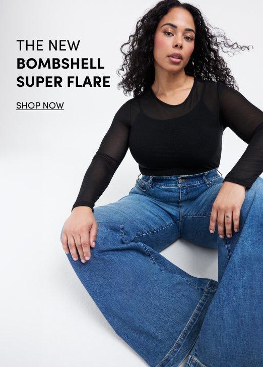 Model wearing a black long-sleeve sheer top with blue Bombshell Super Flare jeans, seated against a light gray background. Text reads, “The New Bombshell Super Flare.” with a “Shop Now” call to action.