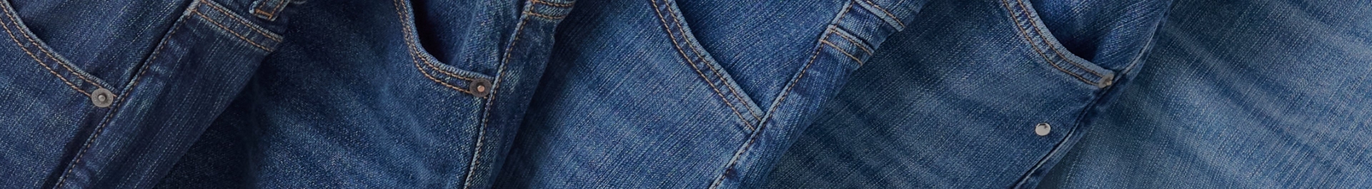 Close-up texture of dark indigo blue denim fabric showing the diagonal twill weave pattern with small white flecks throughout. No people, text, or other elements are present in the image.