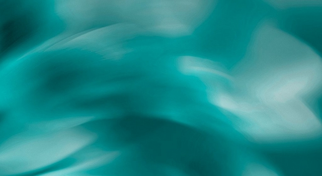 Abstract wide banner image of a teal blue gradient background with soft cloud-like light and dark swirling patterns, transitioning to a lighter grayish teal on the right side. No people, text, or objects are present in the image.