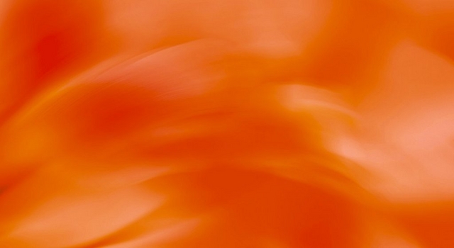 Abstract wide banner image of an orange and red gradient background with soft swirling light patterns, transitioning to a lighter peachy orange on the right side. No people, text, or objects are present in the image.