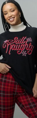 Model wearing a holiday sweatshirt and plaid skirt.