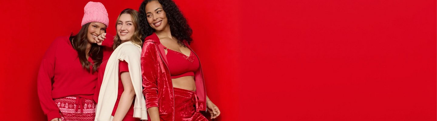 Three models wear cozy red and cream holiday styles against a red background.