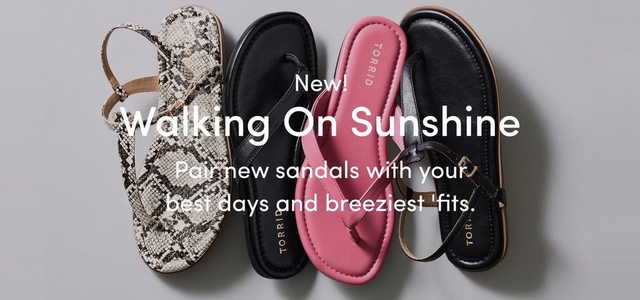 'A wide promotional banner with a light gray background. On the left in dark text reads New! Walking On Sunshine, with smaller dark text below reading Pair new sandals with your best days and breeziest 'fits. On the right, four sandals are displayed upright side by side. From left to right: a white and gray snakeskin print slingback sandal, a black thong flip flop sandal with a Torrid branded footbed, a pink thong sandal with a Torrid branded footbed, and a black leather sandal with a gold buckle detail and a tan sole.'