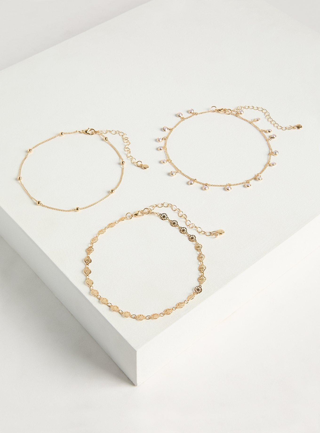 A plus-size anklet three-pack with gold-chain, gold-bead, and pearl anklets